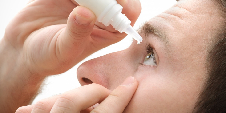 image of a man using eye drops