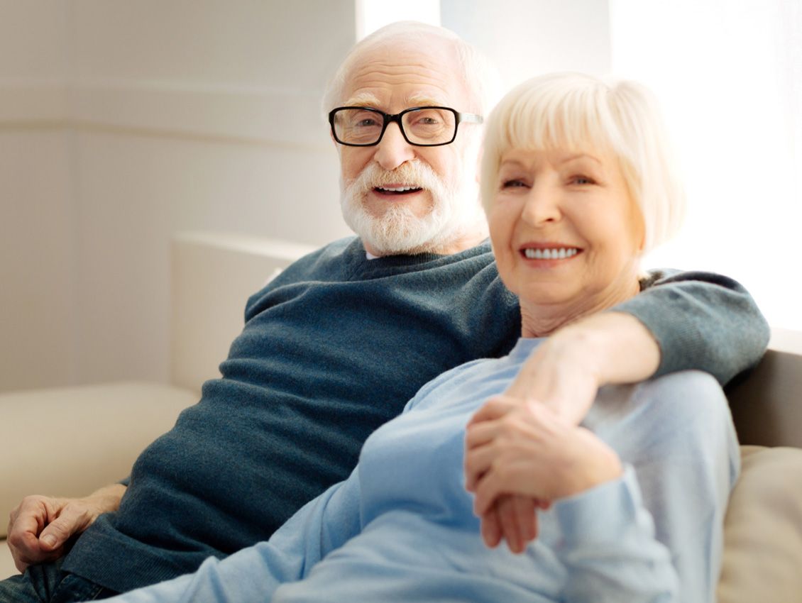 An elderly couple sitting together smiling