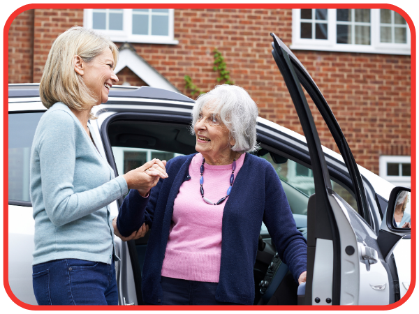 Woman helping elderly woman out of car Woman helping elderly woman out of car