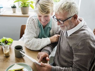 elderly couple looking at tablet
