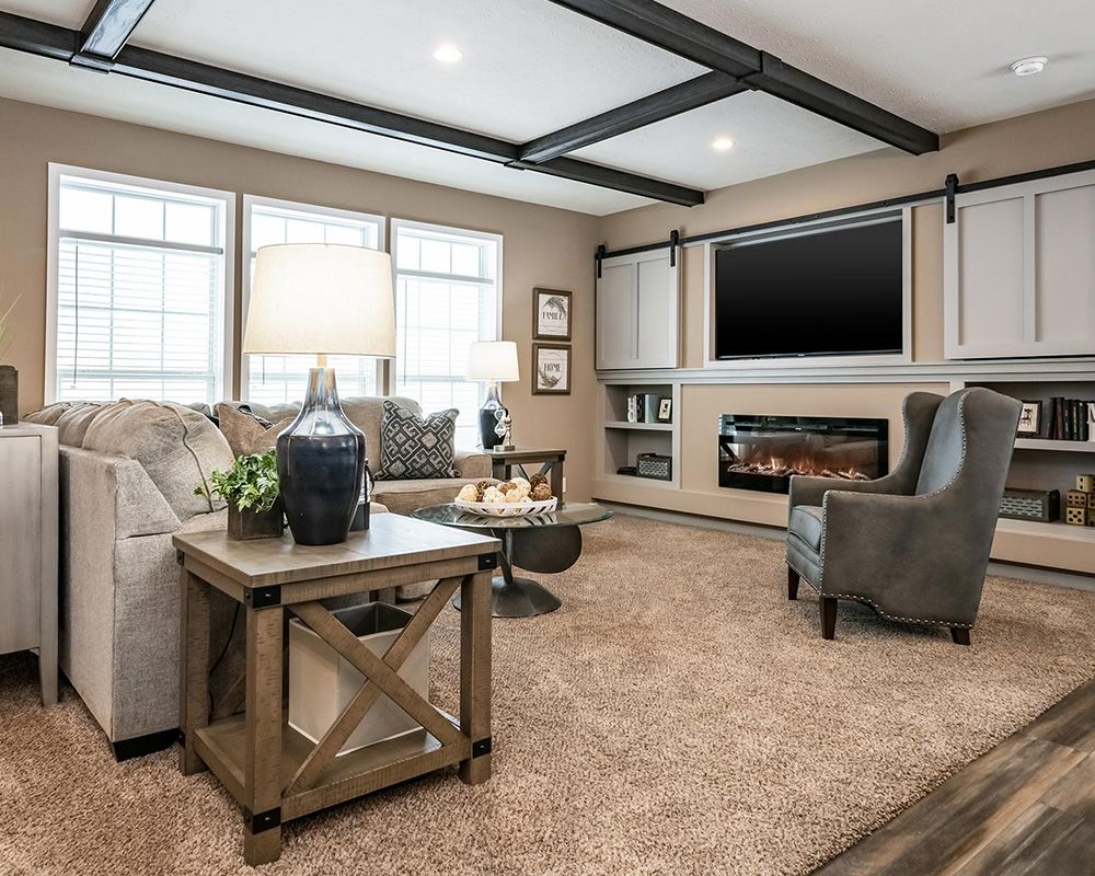 chairs and carpet, and large TV above fireplace