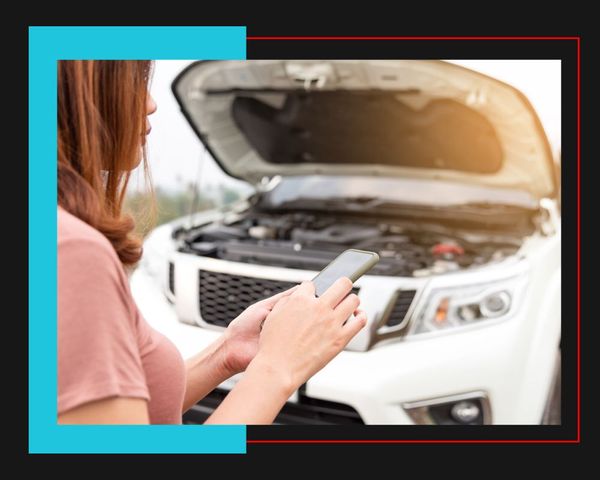 person making phone call in front of open car engine