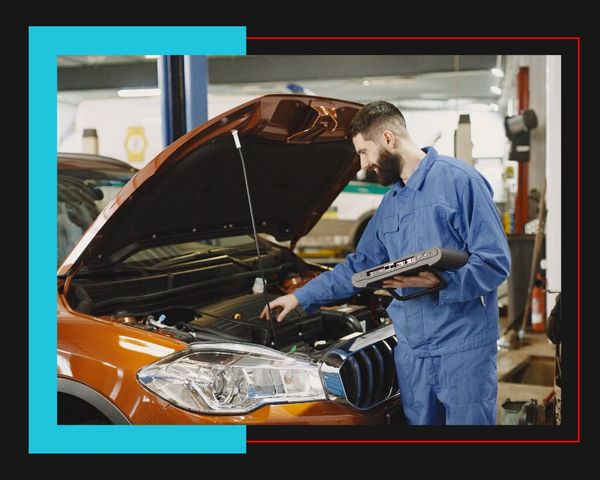 mechanic looking into car engine