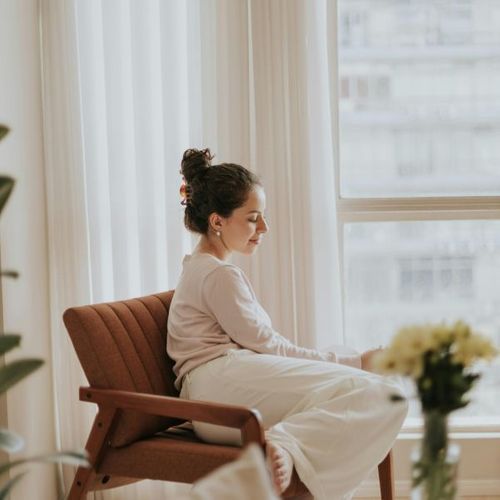 woman relaxing in the arm chair in a clean organized environment