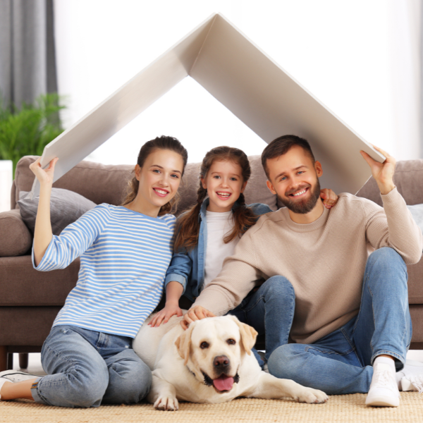 Happy family holding a cardboard roof over their heads. 