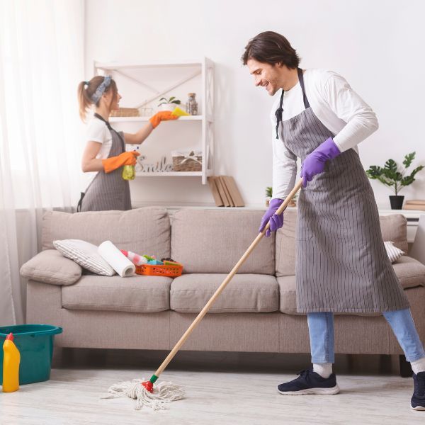 Two workers cleaning a living space