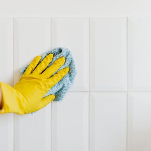 golved hand scrubbing wall with a cloth