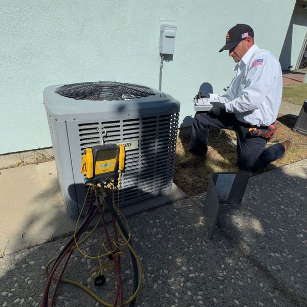 tech looking at HVAC unit