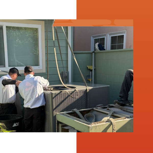 Two HVAC technicians working on installing a condenser unit outside of a home