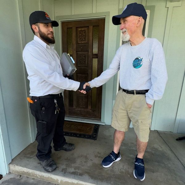 HVAC tech and homeowner shaking hands
