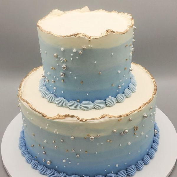 Two-layered cake with blue frosting and gold decorations