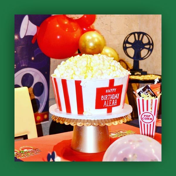 Birthday cake stylized as a tub of popcorn