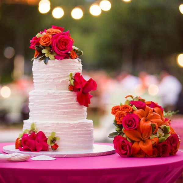 a three tiered wedding cake with roses