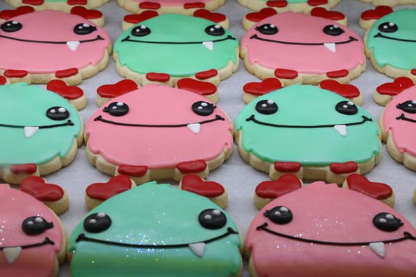 monster cookies lined up in alternating color patterns of pink and green