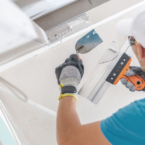 Man using a scraper for dry wall