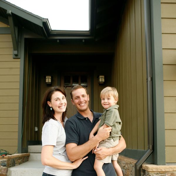 smiling family outside home