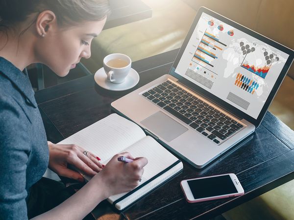 Woman sitting in a coffee shop working on business plans.