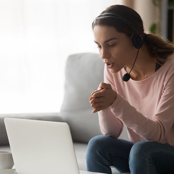 Focused young woman online teacher coaching teaching by video call.