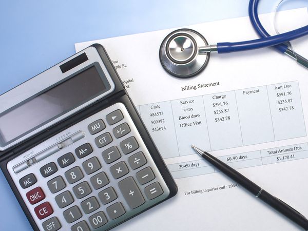 Health care billing statement with stethoscope, pen and calculator. 