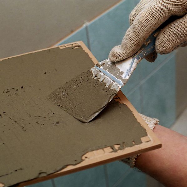 man putting grout on tile