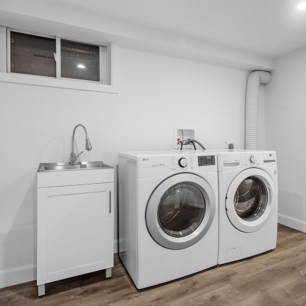 White laundry room with vinyl plank flooring