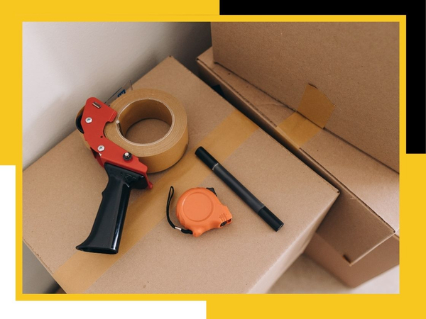 packing tape, marker, measuring tape on moving boxes