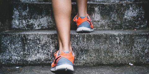 person climbing stairs in orange athletic shoes