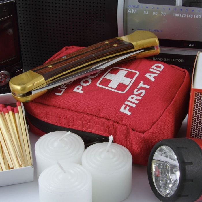 emergency kit that includes candles, first aid, flashlight, and a pocket knife
