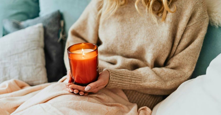 woman on couch holding a lit candle