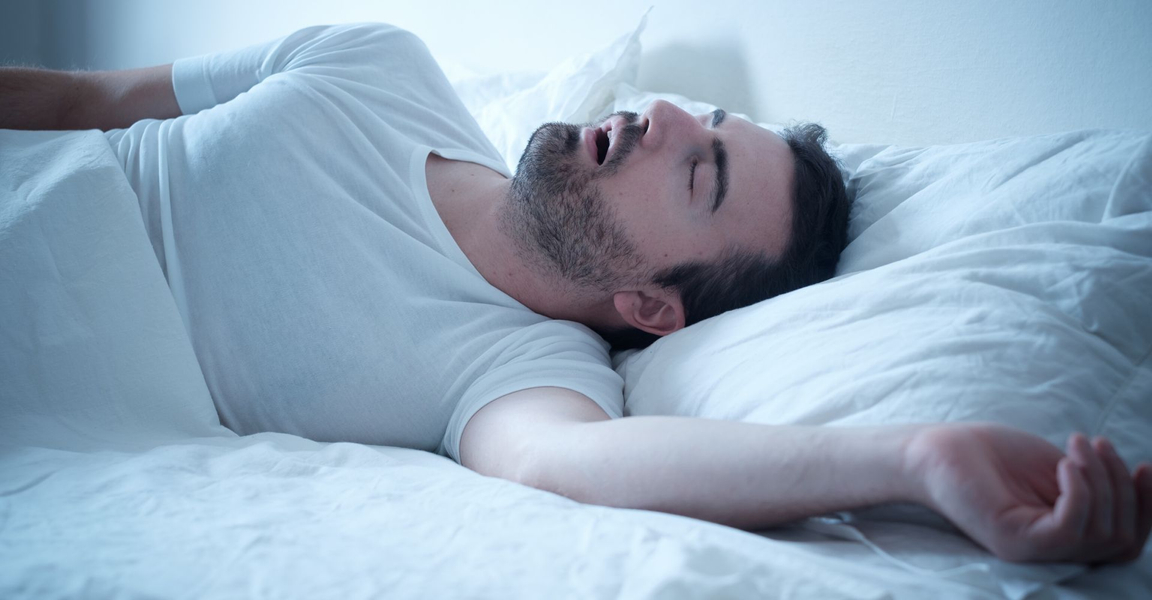 man lying in bed snoring