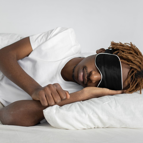 man sleeping on his side with sleep mask