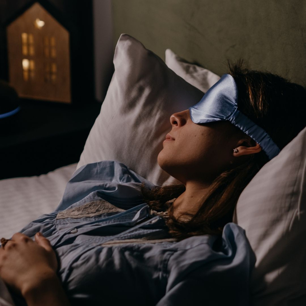 Woman wearing a sleep mask in bed