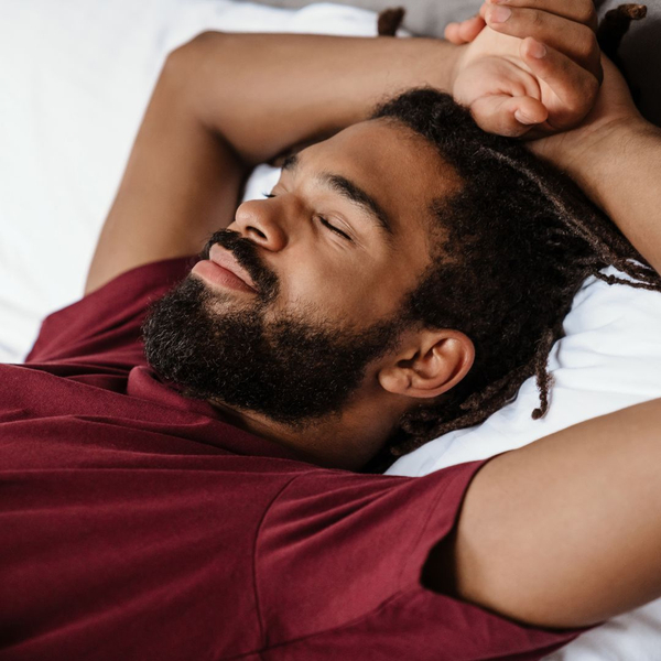 man sleeping happy with arms above head