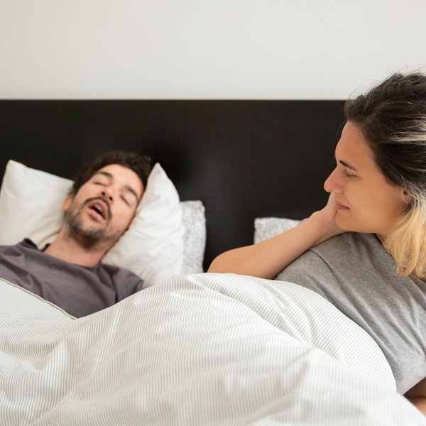 Couple in bed with one of them snoring