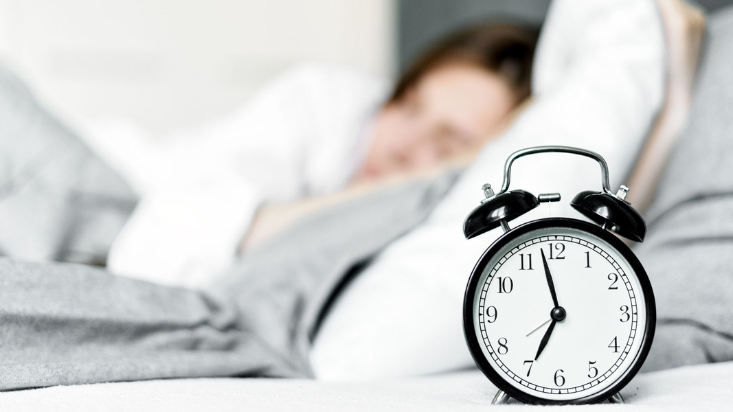 person sleeping in background with alarm 