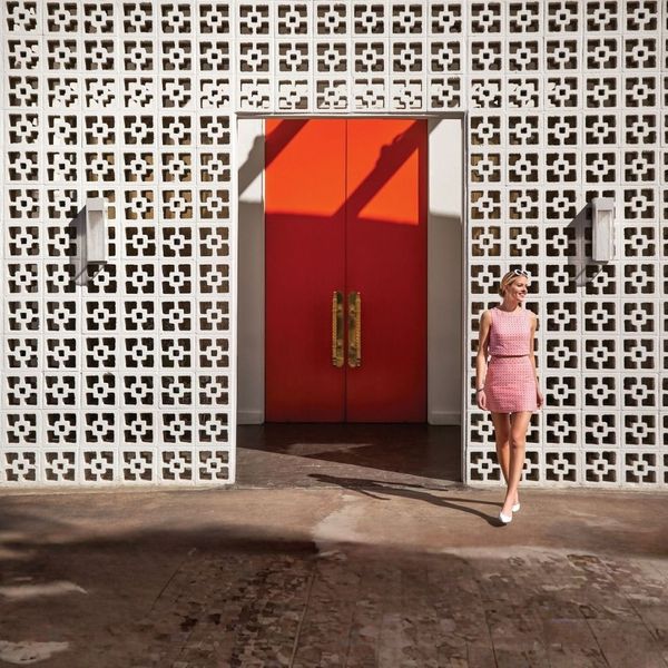 woman in front of trendy white wall with sconces