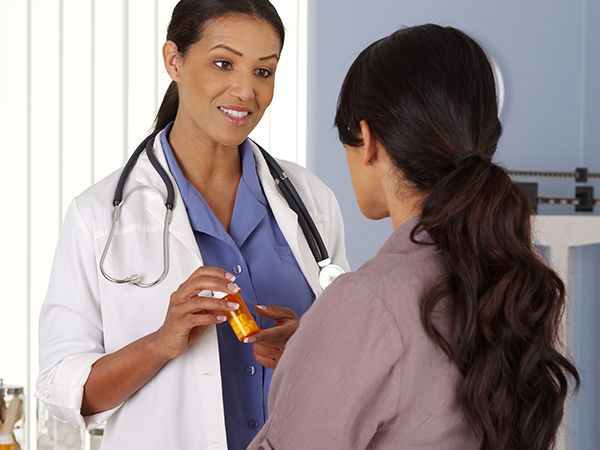 a doctor talking with a patient about a bottle of medicine