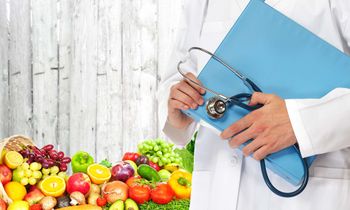 a doctor standing with a lot of fruits and vegetables