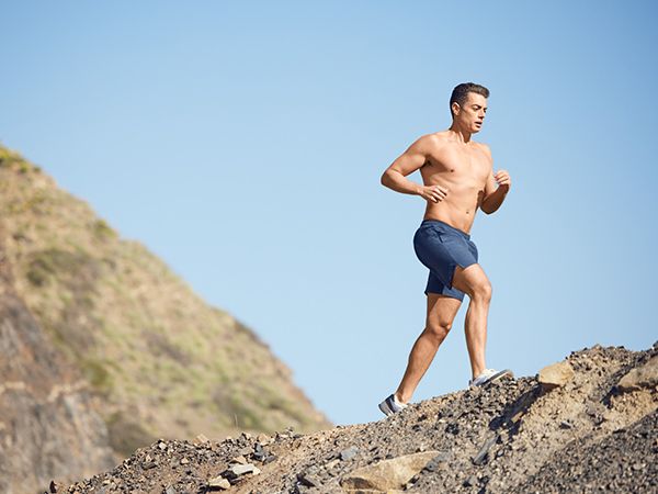 a shirtless man jogging up a hill