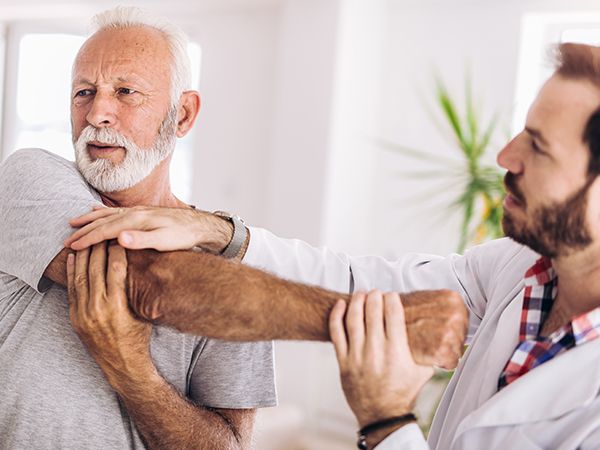 a doctor testing the range of motion on a clients shoulder