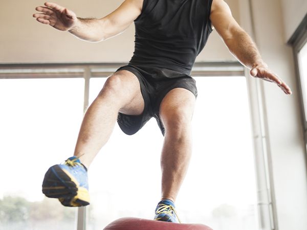 a man standing on a balance ball on one foot