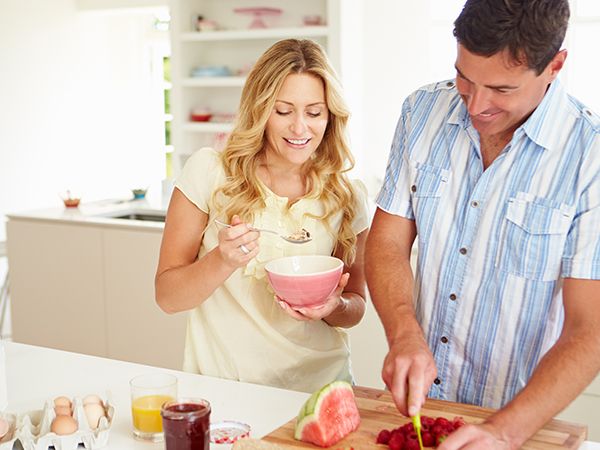 a man and woman making breakfast together