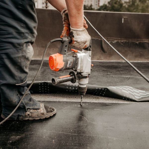 man laying down a commercial roof