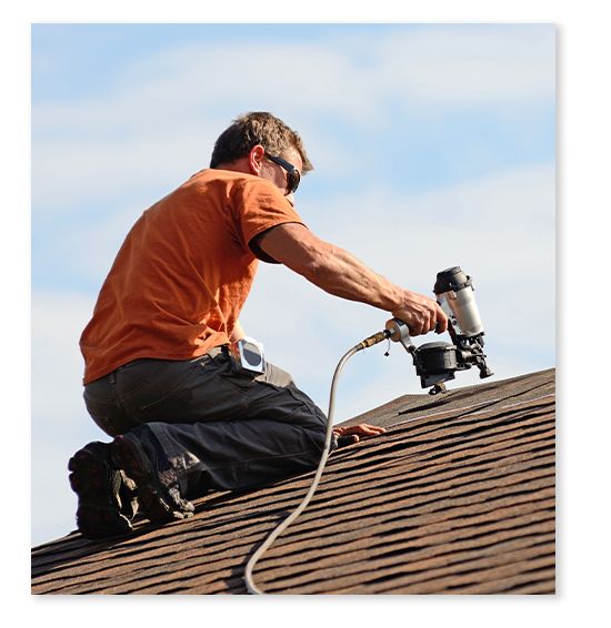 a person using a nail gun to attach shingles to a roof