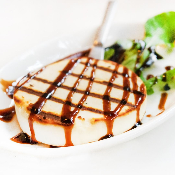 An image of Manouri cheese with balsamic vinegar on top.
