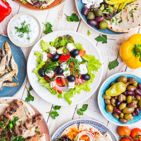 An image of various Greek foods on colorful plates.