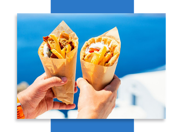 Hands holding two gyros in Greece