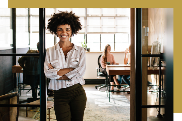 proud small business owner in front of room of employees