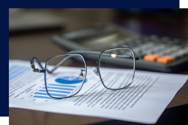 glasses on printed report, calculator in background