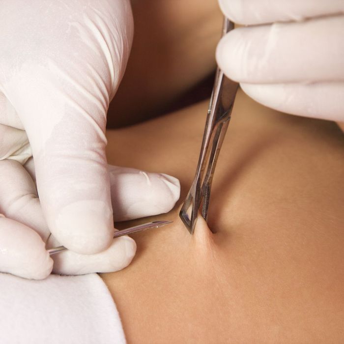 women getting belly button pierced